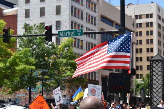 An American flag waved in front of a street light.